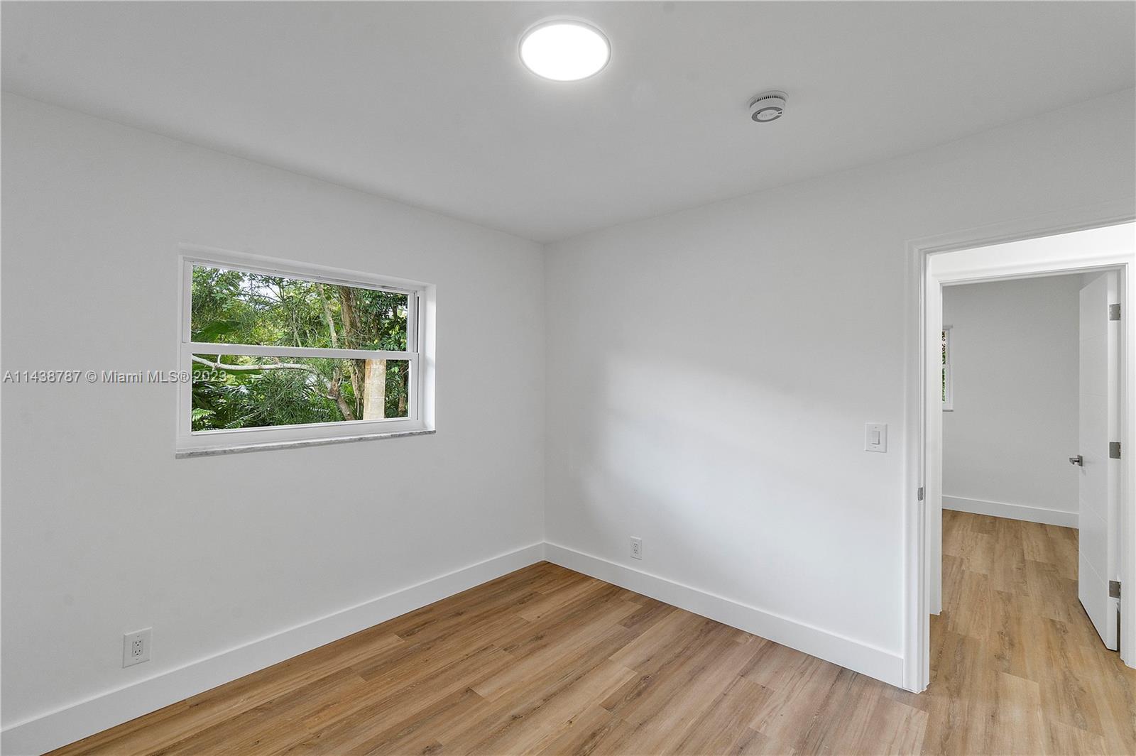 900 Northwest 9th Way Boca Raton, FL 33486 - Photo 40 of 48 an empty room with wooden floor and windows