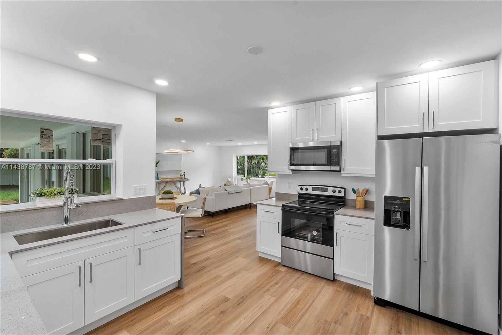 900 Northwest 9th Way Boca Raton, FL 33486 - Photo 10 of 48 a kitchen with sink cabinets stainless steel appliances and wooden floor