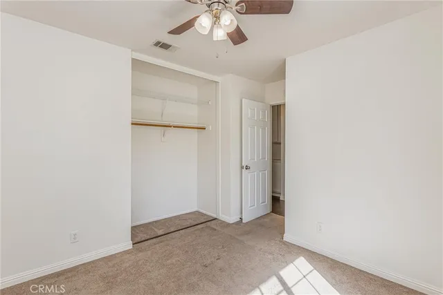 an empty room with chandelier fan