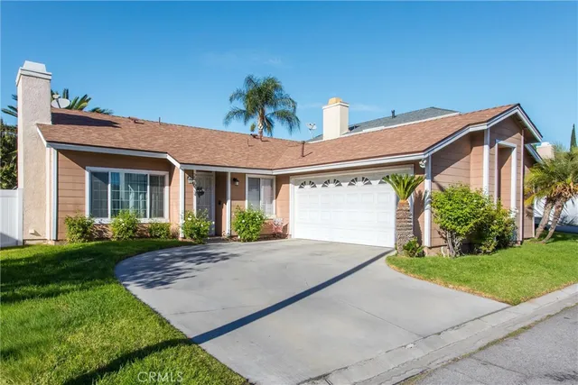 a front view of a house with a yard and potted plants