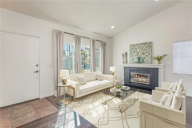 a living room with furniture a fireplace and a large window