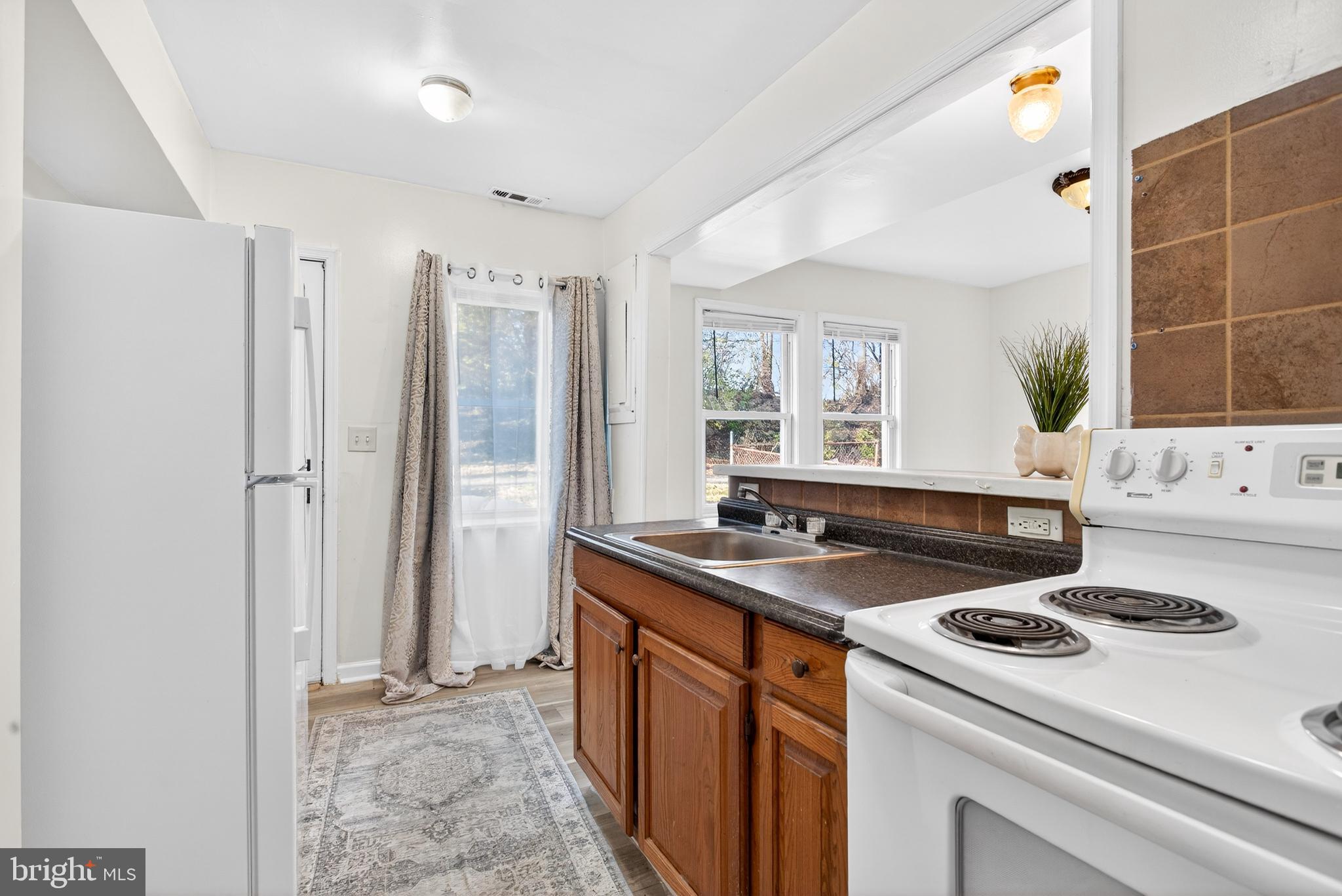 1118 Sterling Avenue Linwood, PA 19061 - Photo 17 of 38 a kitchen with a stove a sink and a refrigerator