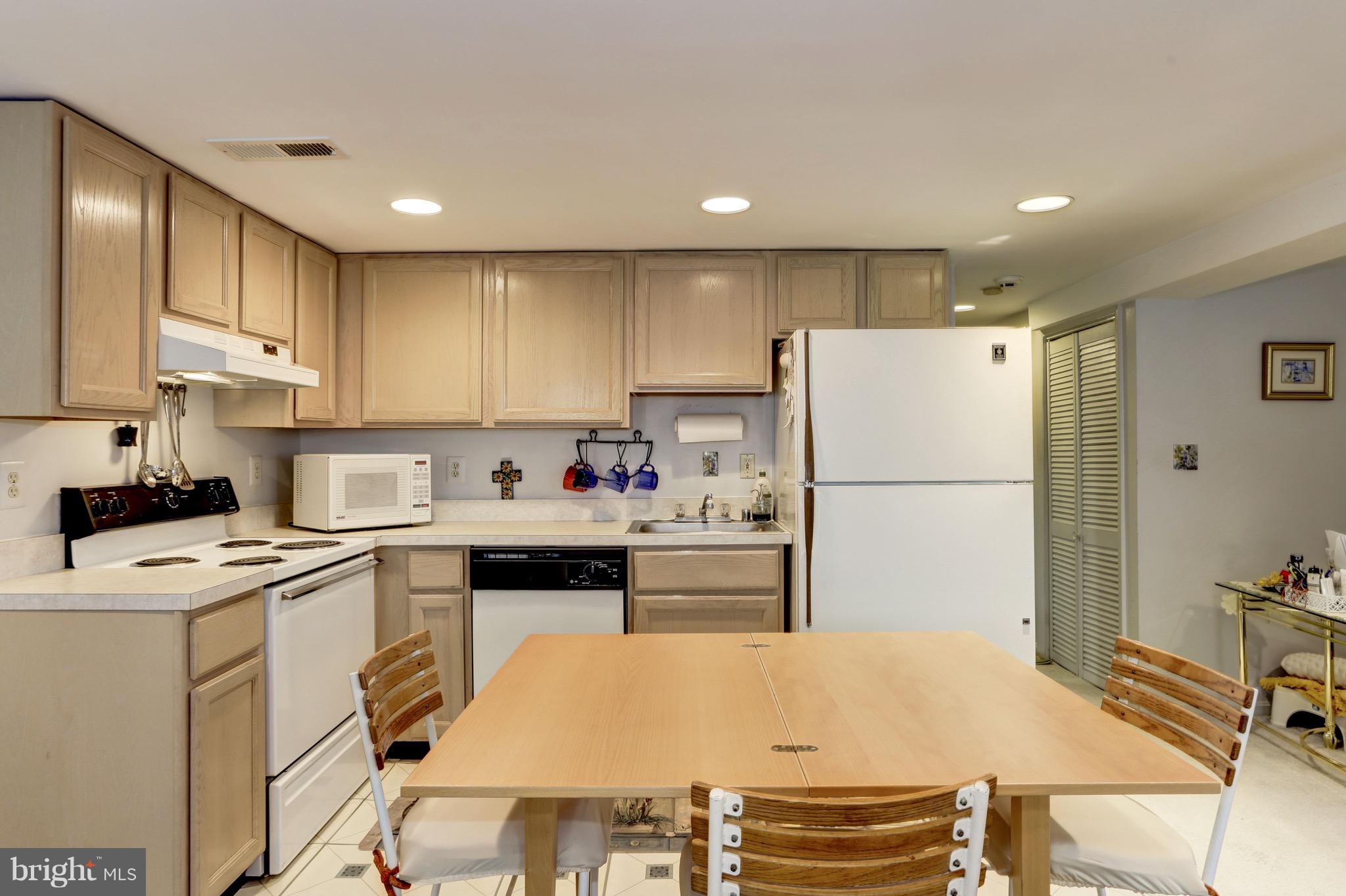 224 9th Street Southeast Washington, DC 20003 - Photo 23 of 29 a kitchen with a refrigerator a stove a sink and white cabinets with wooden floor