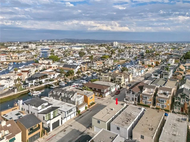an aerial view of a city with lots of residential buildings and mountain view in back