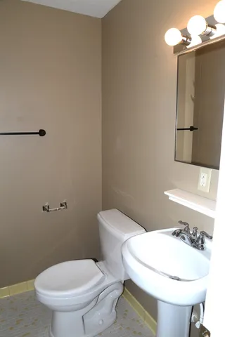 a white toilet sitting next to a bathroom sink