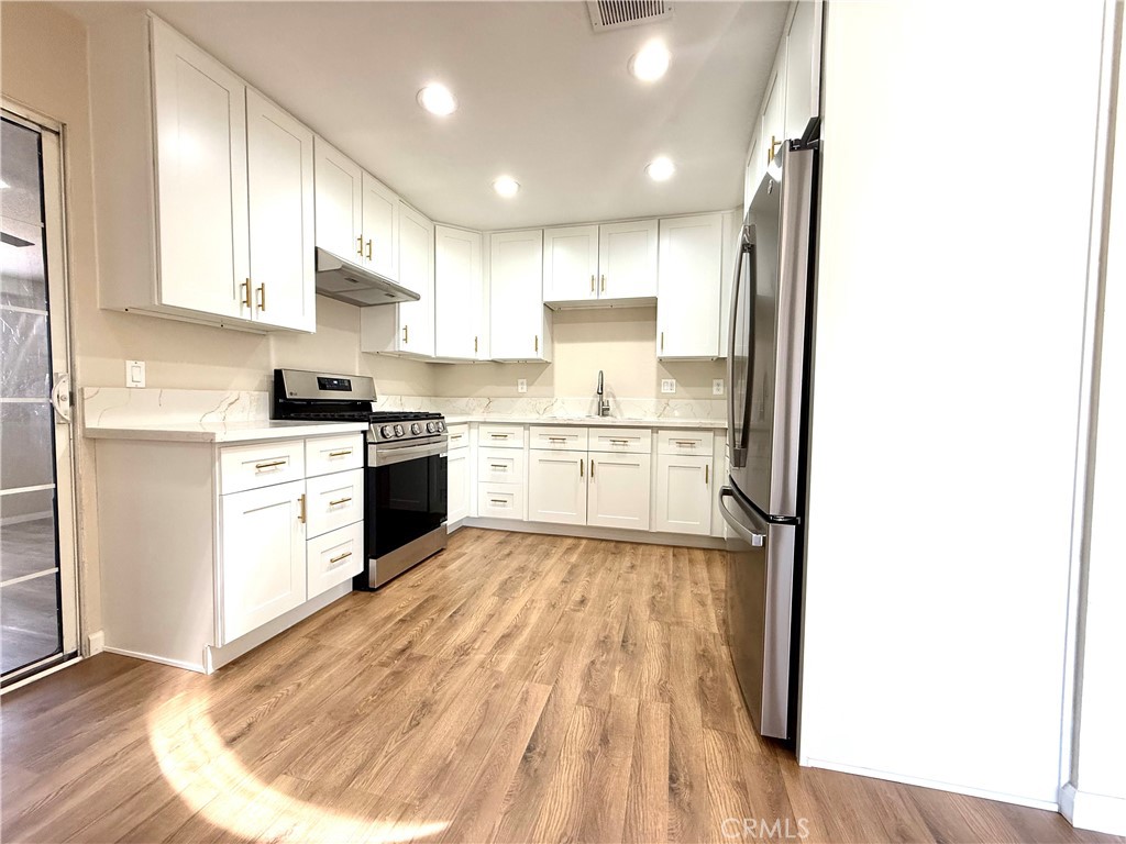930 West Franklin Avenue Ridgecrest, CA 93555 - Photo 12 of 31 a large kitchen with a white stove top oven and white cabinets