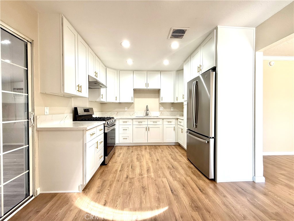 930 West Franklin Avenue Ridgecrest, CA 93555 - Photo 13 of 31 a kitchen with a refrigerator a stove top oven a sink and cabinets