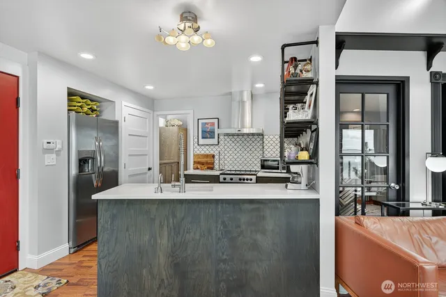a kitchen with kitchen island granite countertop a refrigerator a stove and a sink