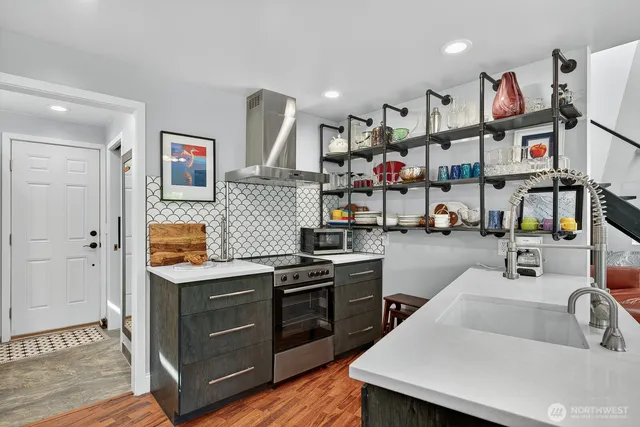 a kitchen with stainless steel appliances granite countertop a sink and a refrigerator