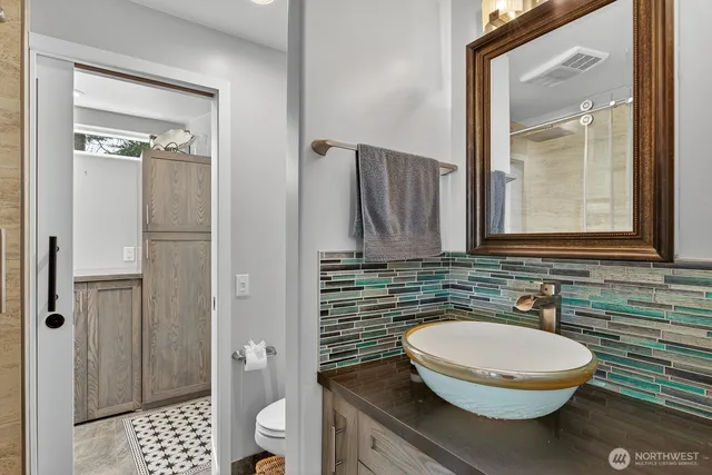 a bathroom with a sink a toilet and shower