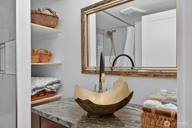 a bathroom with a granite countertop sink and a mirror