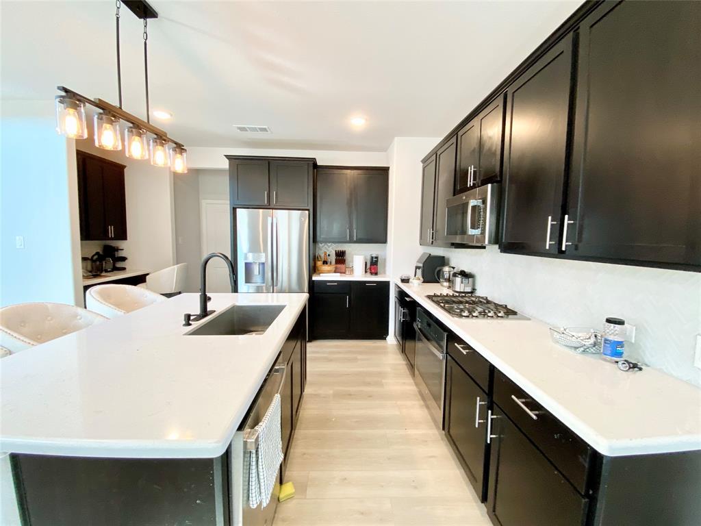 1510 Verbena Lane Garland, TX 75042 - Photo 4 of 10 a large kitchen with stainless steel appliances a sink a stove and a refrigerator