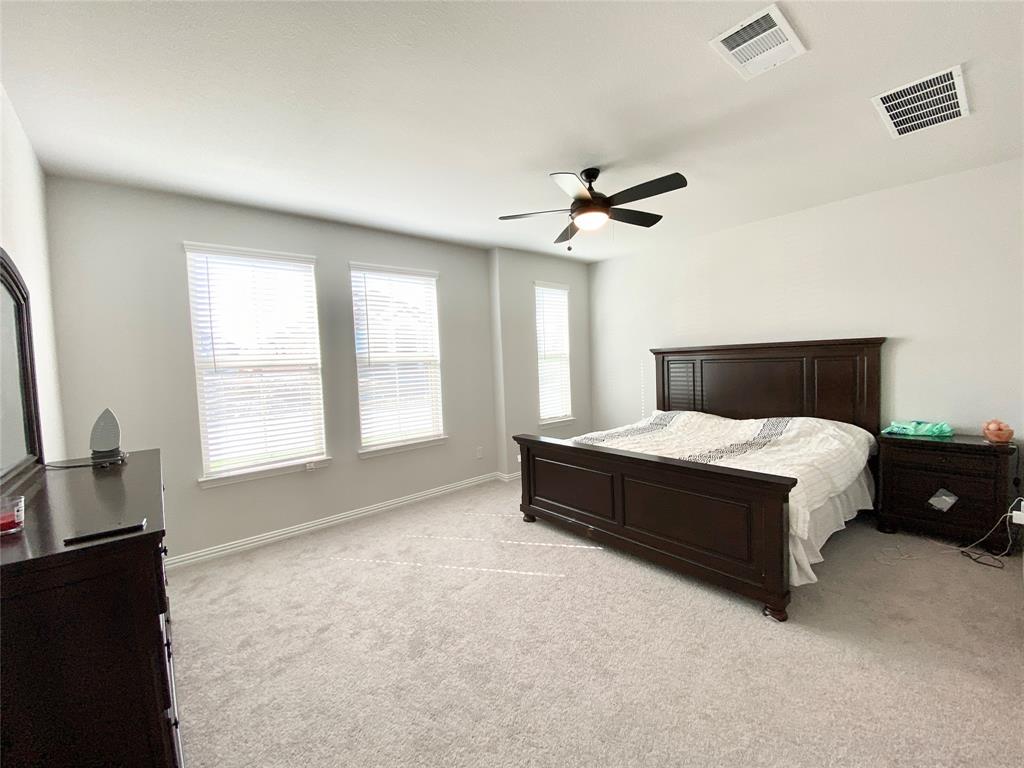 1510 Verbena Lane Garland, TX 75042 - Photo 5 of 10 a spacious bedroom with a large bed and a chandelier