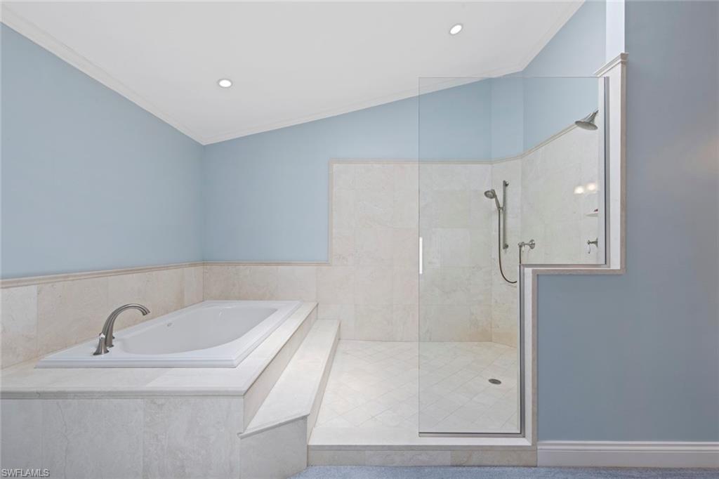 589 Neapolitan Way Naples, FL 34103 - Photo 11 of 27 a bathroom with a bathtub and a shower