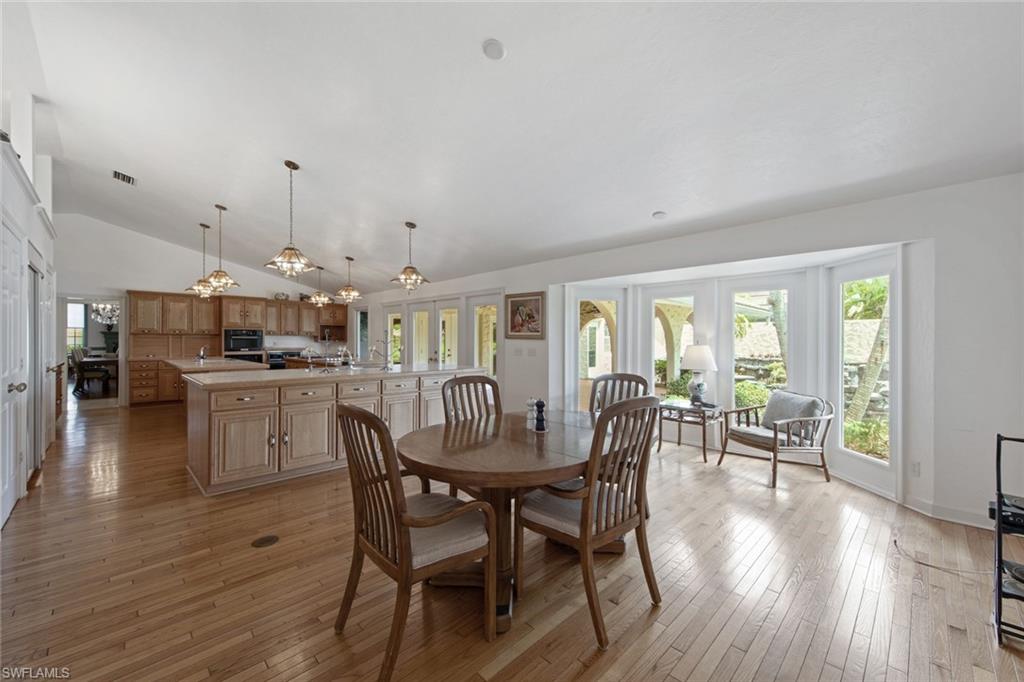 589 Neapolitan Way Naples, FL 34103 - Photo 13 of 27 a dining room with furniture and wooden floor