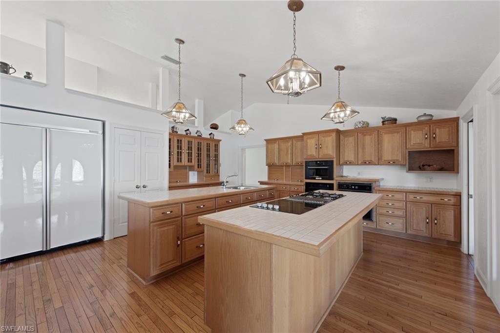 589 Neapolitan Way Naples, FL 34103 - Photo 16 of 27 a kitchen with cabinets a counter and stainless steel appliances