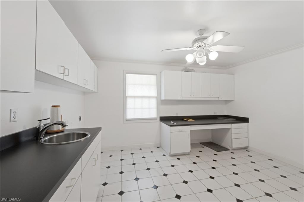 589 Neapolitan Way Naples, FL 34103 - Photo 20 of 27 a kitchen with a sink a stove and a microwave