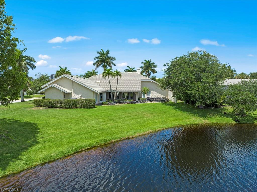 589 Neapolitan Way Naples, FL 34103 - Photo 23 of 27 a front view of a house with garden