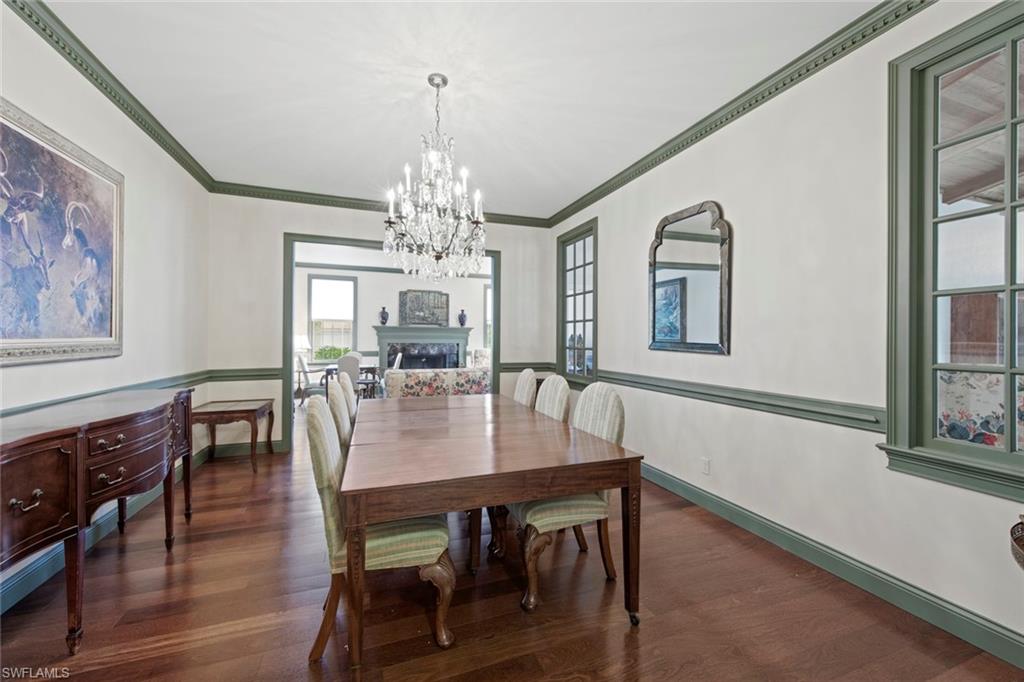589 Neapolitan Way Naples, FL 34103 - Photo 4 of 27 a view of a dining room with furniture a chandelier and wooden floor