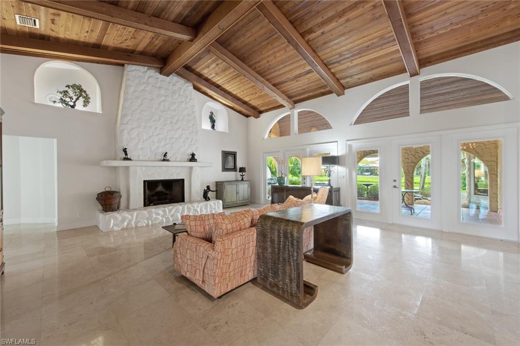 589 Neapolitan Way Naples, FL 34103 - Photo 6 of 27 a living room with furniture and a fireplace