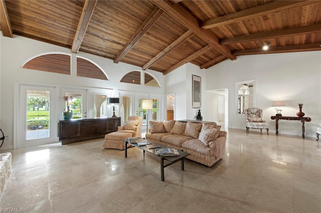 589 Neapolitan Way Naples, FL 34103 - Photo 7 of 27 a living room with furniture and a chandelier