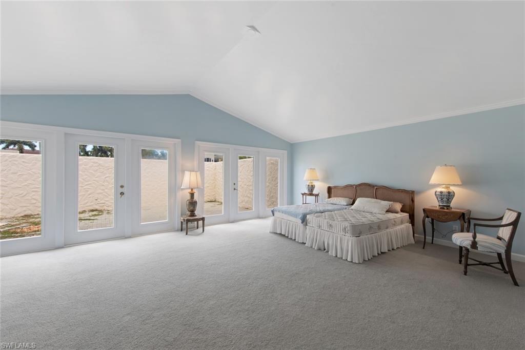 589 Neapolitan Way Naples, FL 34103 - Photo 8 of 27 a bed room with furniture and night stand