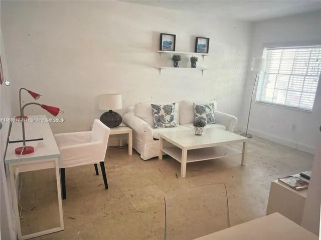 a living room with furniture a rug and white walls