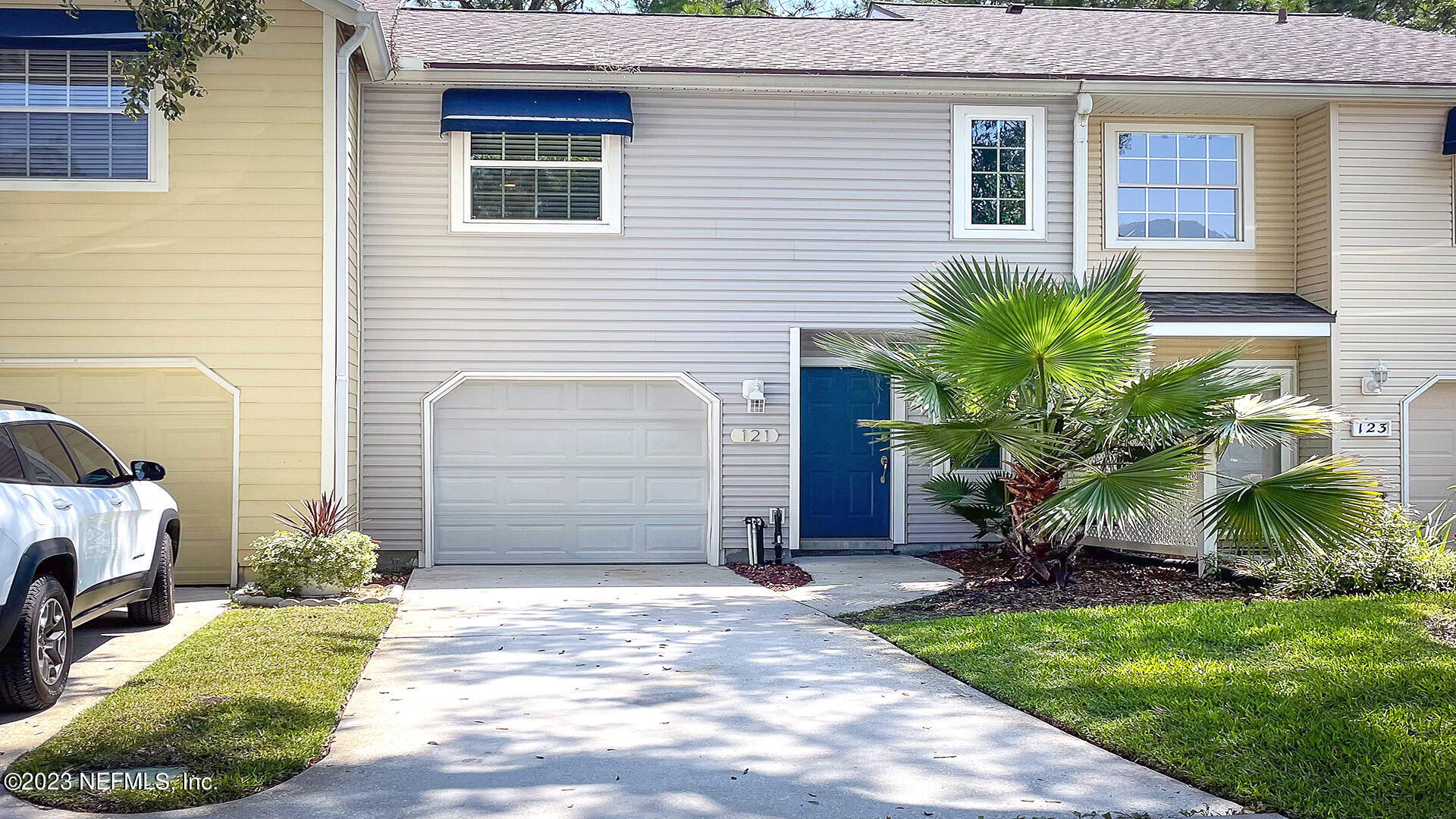 121 Sand Castle Way Neptune Beach, FL 32266 - Photo 2 of 39 a front view of a house with a yard and garage