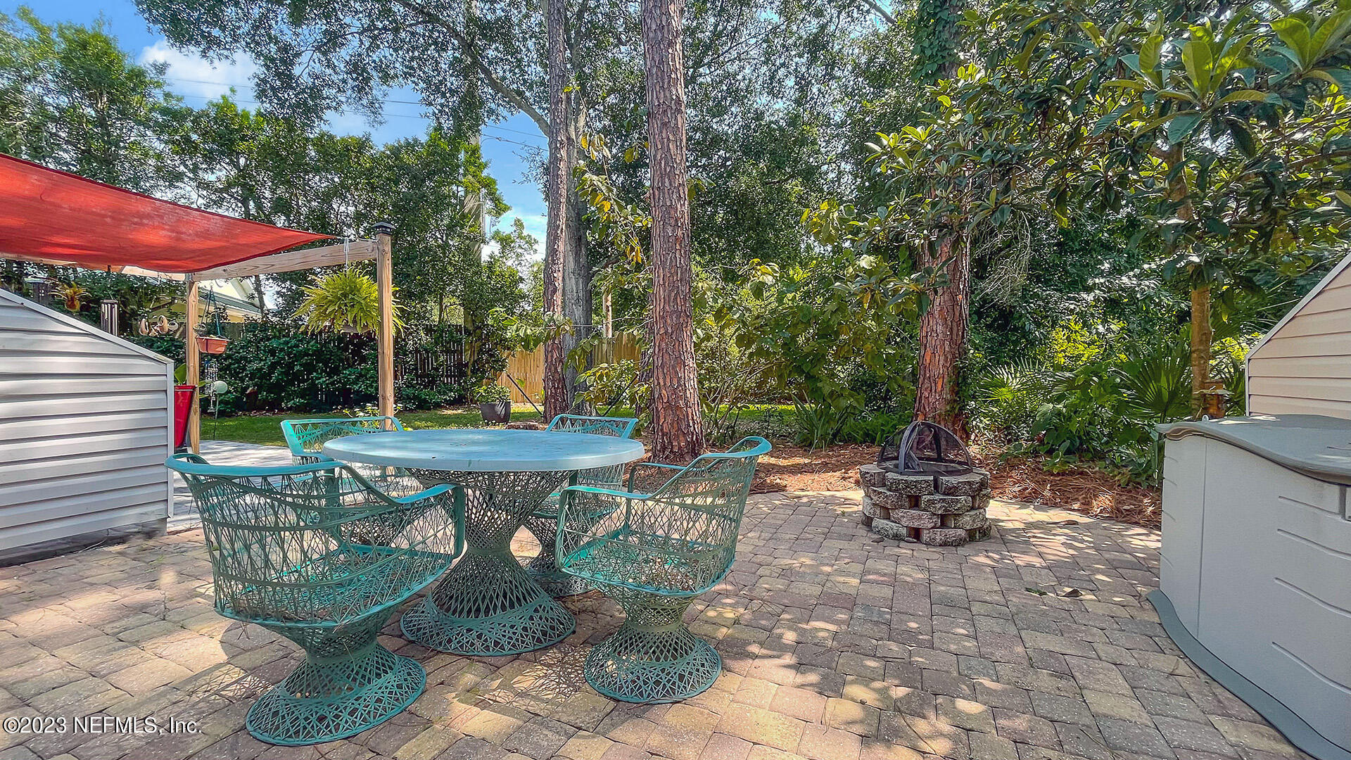 121 Sand Castle Way Neptune Beach, FL 32266 - Photo 28 of 39 a view of a backyard with table and chairs under an umbrella