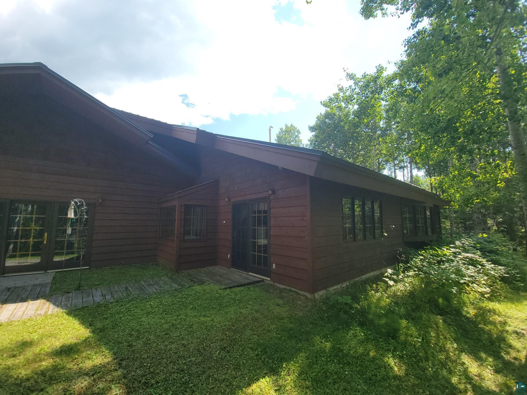 181 Linnell Road Grand Marais, MN 55604 - Photo 13 of 77 Wood-sided exterior with multiple windows and two sets of French doors