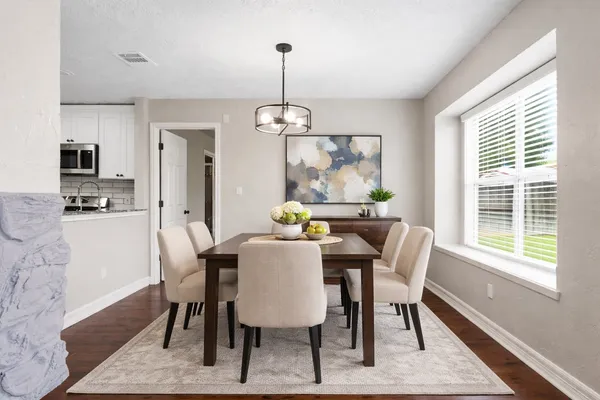 a dining room with furniture a chandelier and wooden floor