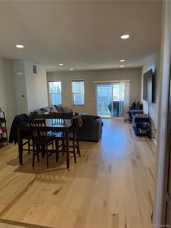 a view of a a dining room with furniture window and wooden floor