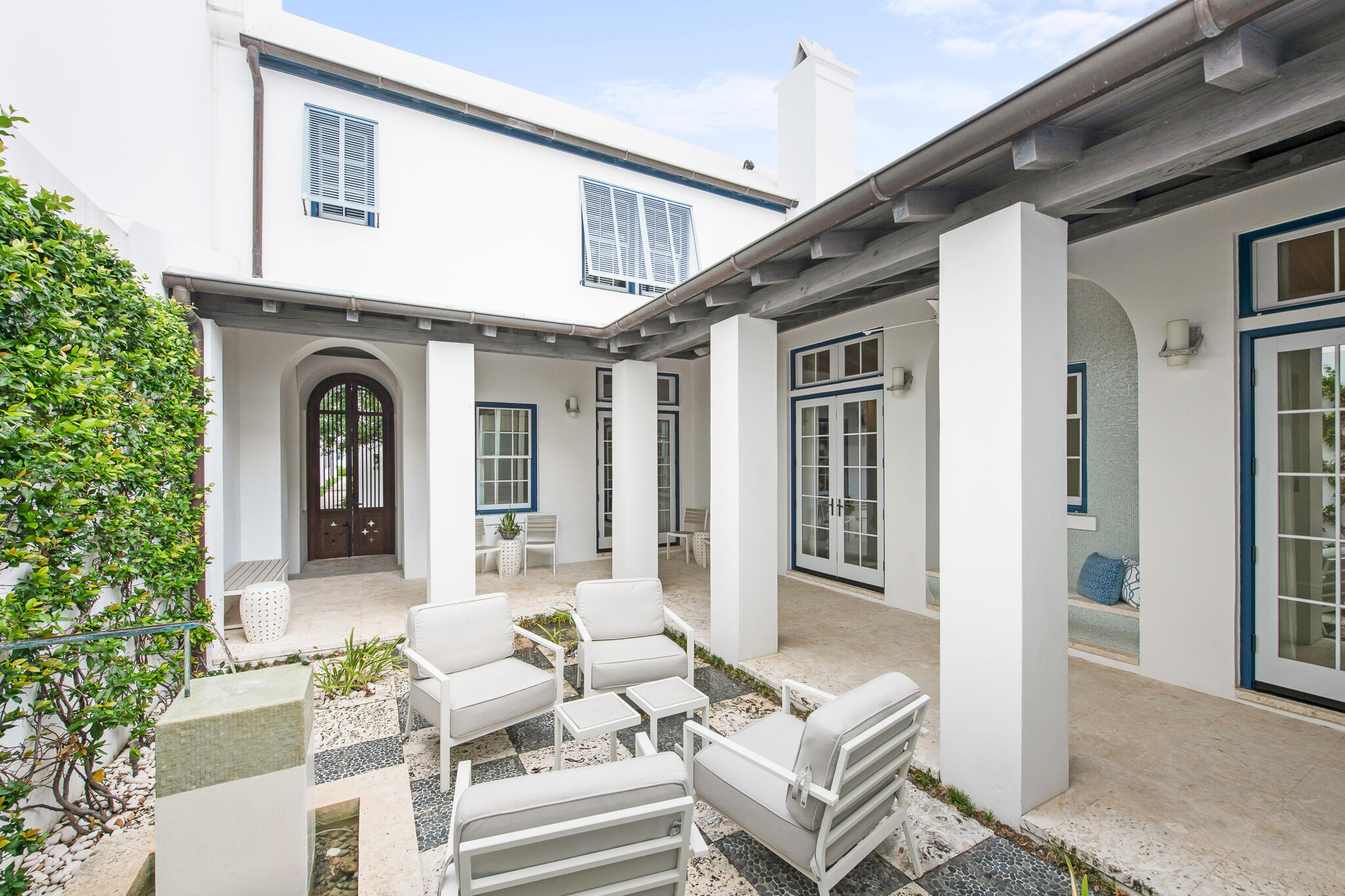 a front view of a house with couches and potted plants