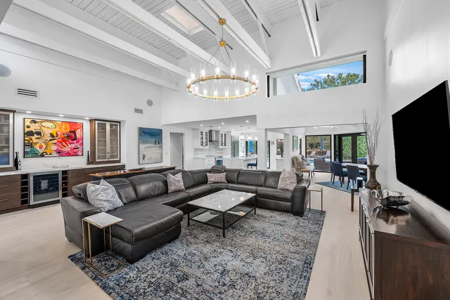 a living room with furniture a chandelier and a rug