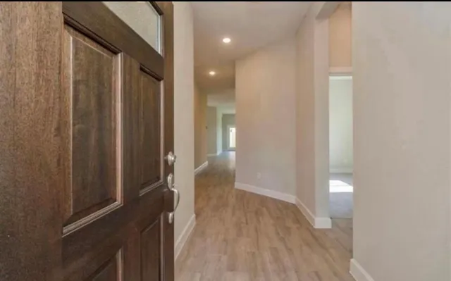 a view of a hallway with wooden floor and staircase