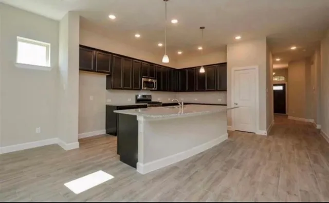 a kitchen with kitchen island cabinets and refrigerator
