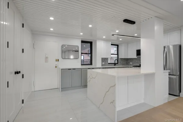 a kitchen with stainless steel appliances kitchen island granite countertop a refrigerator and a stove top oven