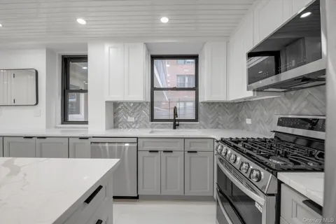 a kitchen with stainless steel appliances a sink stove and cabinets
