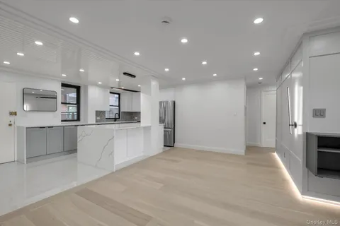 a view of kitchen with kitchen island white cabinets and stainless steel appliances