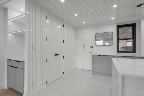 a view of kitchen with refrigerator and white cabinets