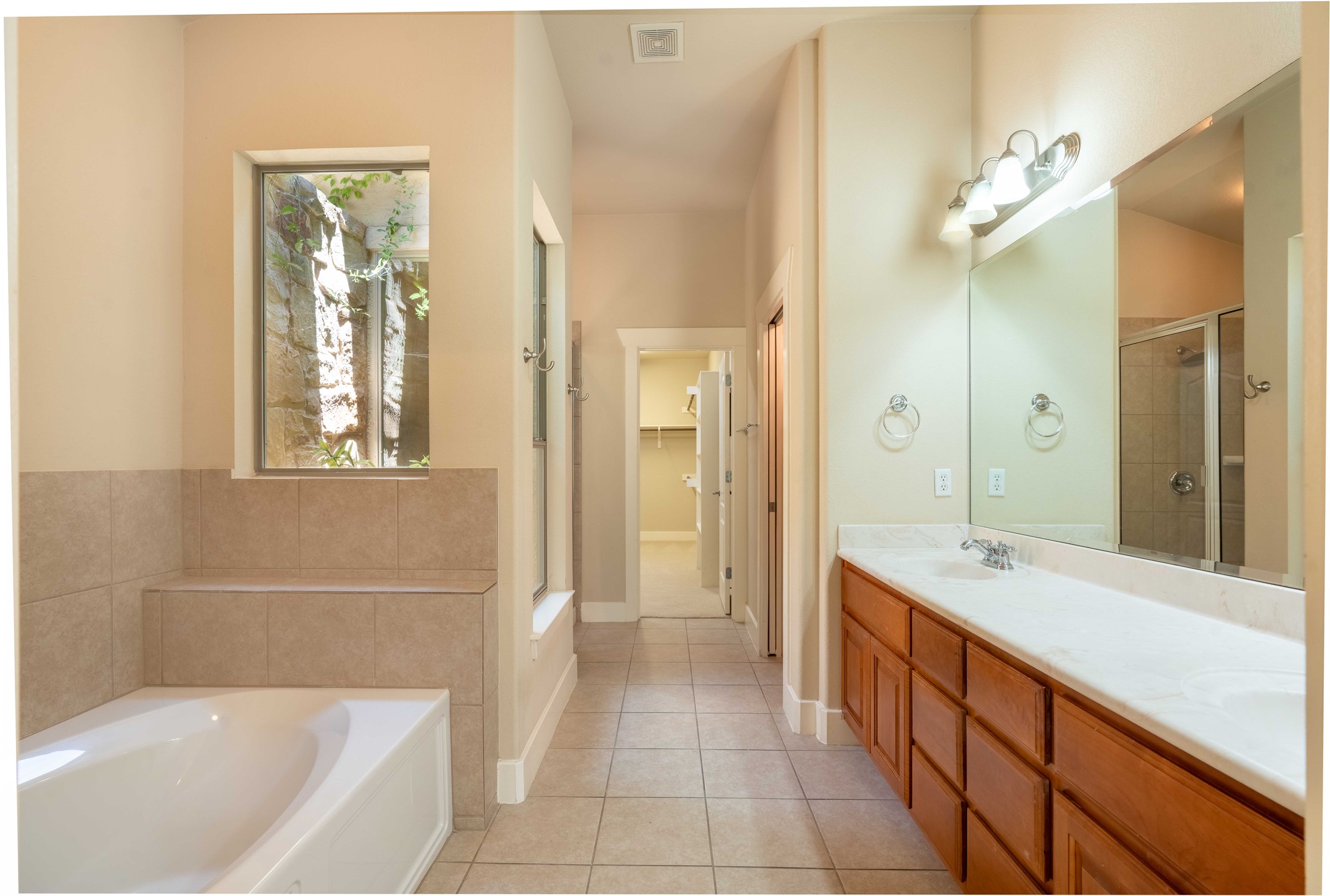 210 Rivulet Lane Austin, TX 78738 - Photo 15 of 28 Clean lines and a spacious layout define this well-appointed bathroom, offering both a relaxing tub and a convenient shower.