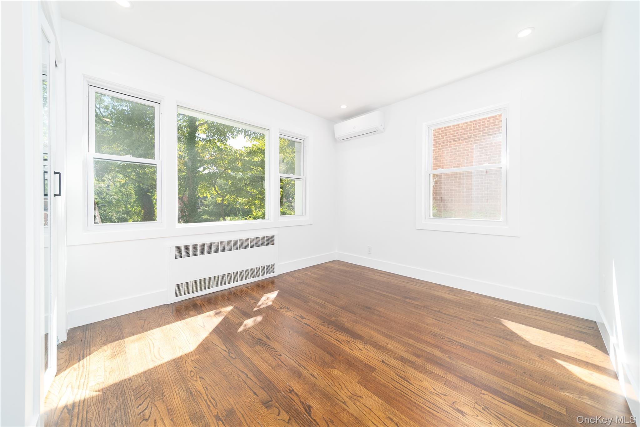 86-32 Midland Parkway Queens, NY 11432 - Photo 15 of 26 a view of an empty room with wooden floor and a window