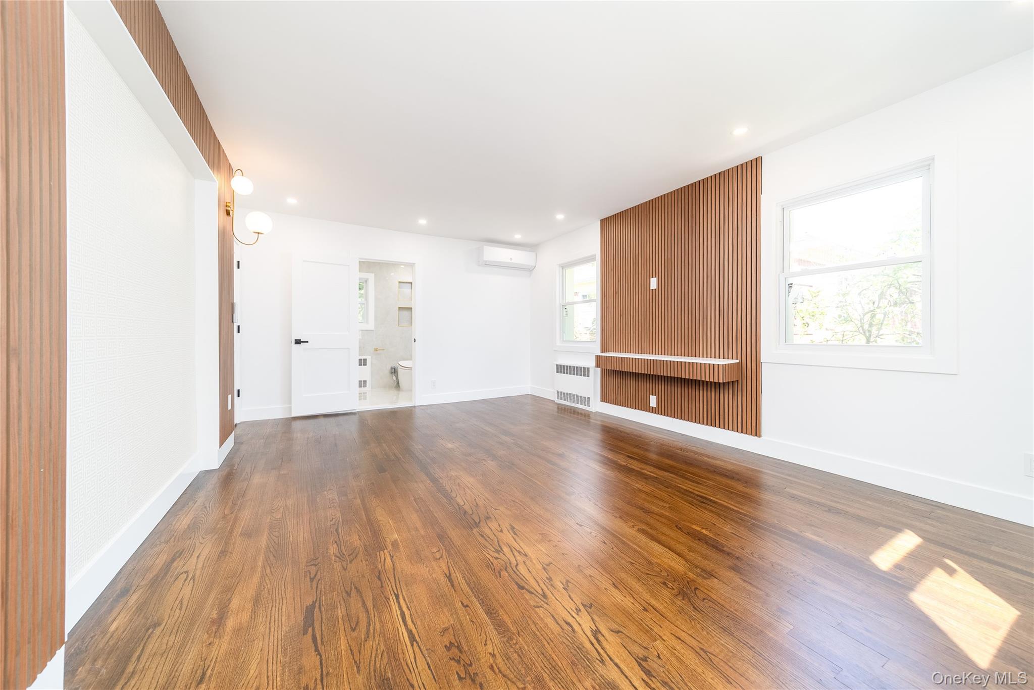86-32 Midland Parkway Queens, NY 11432 - Photo 16 of 26 a view of an empty room with wooden floor and a window