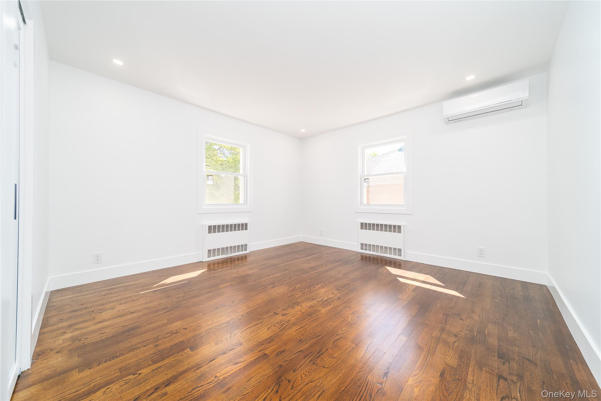 86-32 Midland Parkway Queens, NY 11432 - Photo 18 of 26 a view of an empty room with wooden floor and a window