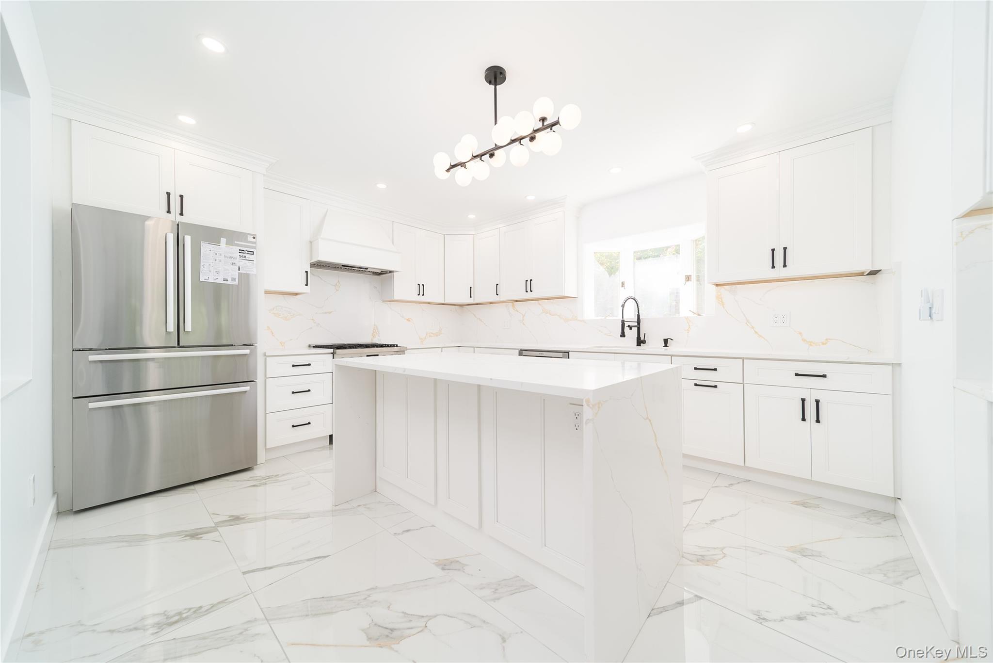 86-32 Midland Parkway Queens, NY 11432 - Photo 3 of 26 a kitchen with white cabinets and stainless steel appliances