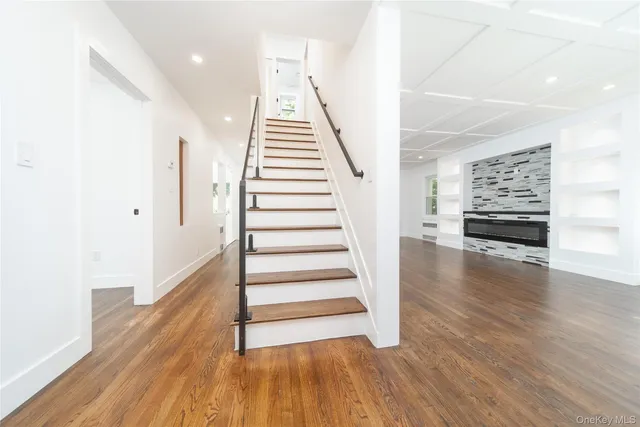 a view of a livingroom with wooden floor and stairs