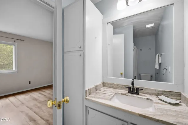 a bathroom with a granite countertop sink and a mirror