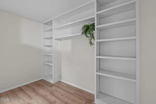 a view of walk in closet with empty racks