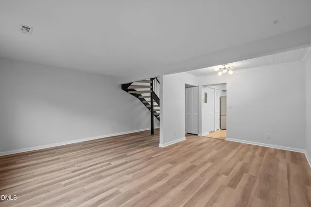 a view of empty room with wooden floor