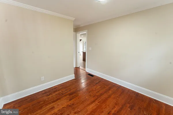 a view of an empty room with wooden floor